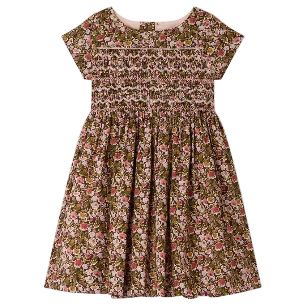 The Girls’ Duchesse Dress by Bonpoint features a short-sleeve silhouette with a floral print in pink, green, and brown tones. Made from soft organic cotton Liberty fabric, it includes a smocked bodice and gathered skirt for an elegant look.