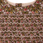 Close-up of the Girls’ Duchesse Dress by Bonpoint, showing the neckline with a brown, pink, and green floral print on organic cotton Liberty fabric. The design features intricate smocking and zigzag stitching across the chest.