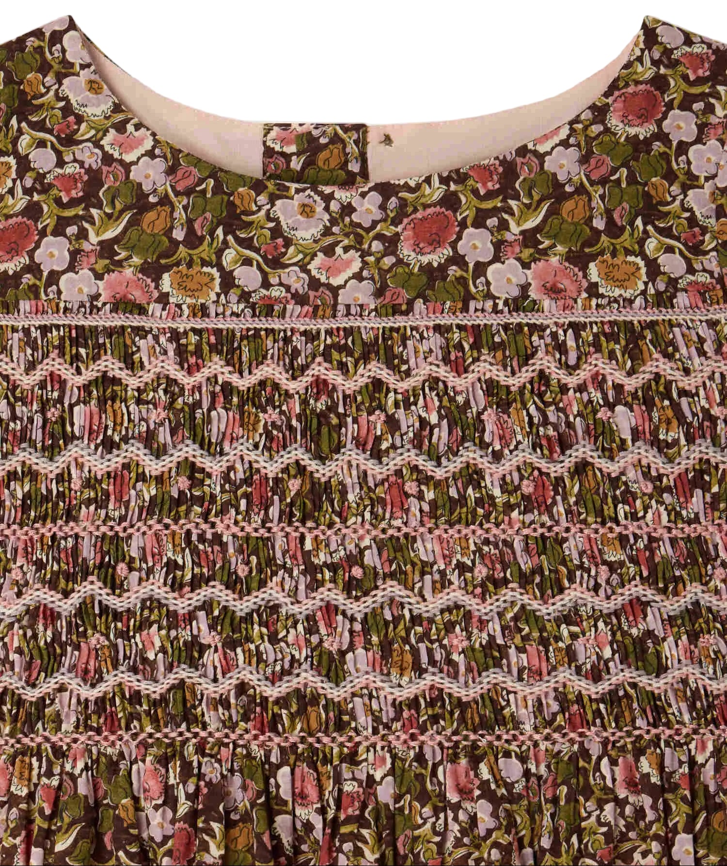 Close-up of the Girls’ Duchesse Dress by Bonpoint, showing the neckline with a brown, pink, and green floral print on organic cotton Liberty fabric. The design features intricate smocking and zigzag stitching across the chest.
