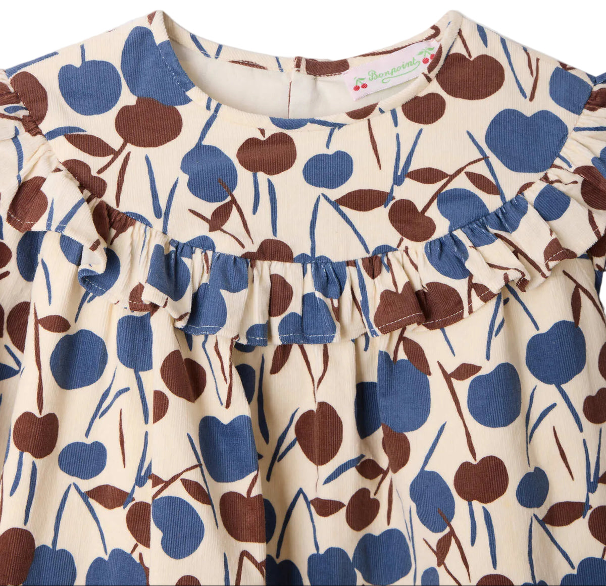 Close-up of the Girls’ Bevika Dress in Organic Cotton Velvet by Bonpoint, featuring a cream-colored fabric with a ruffled collar and a blue and brown abstract floral pattern.