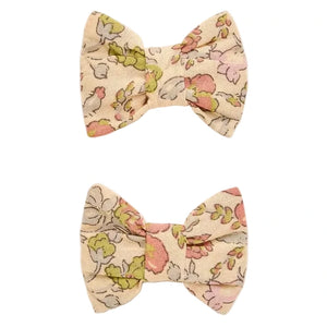 Two Miniclic Barette fabric hair bows by Bonpoint, crafted from Liberty Tana Lawn in a delicate floral pattern featuring pink, green, and beige tones, are displayed against a white background with one positioned above the other. These charming girls’ accessories are perfect for adding a touch of elegance to any outfit.