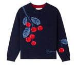 The Girls’ Maxine Sweater by Bonpoint features a navy blue base with intarsia-knit cherries and blue leaves on the front and one sleeve, along with the “Bonpoint” script near the hem—a playful piece that adds a cheerful pop of color to her wardrobe.