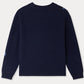 A navy blue, long-sleeve Girls’ Maxine Sweater by Bonpoint is displayed laid flat and viewed from the back, featuring ribbed cuffs, hem, and collar. Subtle blue patches accent one shoulder and sleeve, lending a playful detail to this charming sweater.