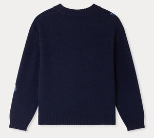 A navy blue, long-sleeve Girls’ Maxine Sweater by Bonpoint is displayed laid flat and viewed from the back, featuring ribbed cuffs, hem, and collar. Subtle blue patches accent one shoulder and sleeve, lending a playful detail to this charming sweater.