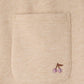 Close-up of a beige fabric pocket on the Bonpoint Girls’ Dalila Joggers, featuring a small embroidered cherry design with two pink sequins as the fruit. These organic cotton joggers combine comfort with playful detail.