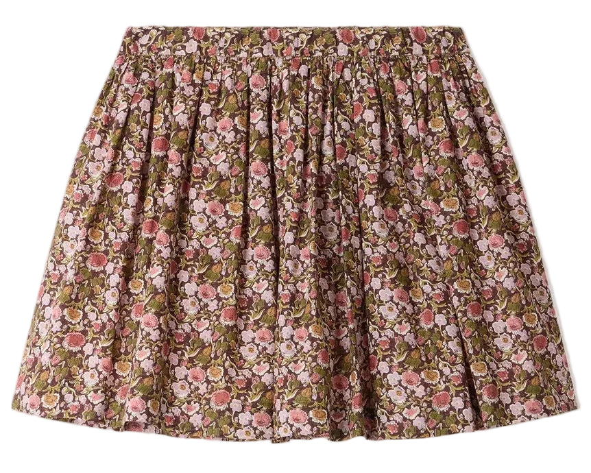 The Girls’ Suzon Skirt by Bonpoint is a knee-length, flared skirt for girls featuring a gathered waist and an all-over floral print in pink, red, and green hues set against a brown background.