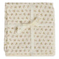Delicately wrapped in a cream ribbon bow, the Doudou Swaddle Blanket by Bonpoint features folded cream-colored organic cotton adorned with petite pink and green florals. This charming bundle is the perfect baby gift—soft against delicate skin and bringing a hint of vintage elegance to every nursery.