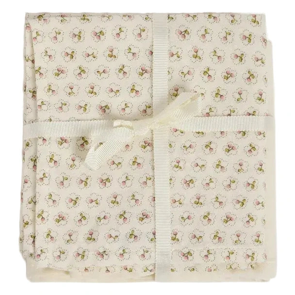 Delicately wrapped in a cream ribbon bow, the Doudou Swaddle Blanket by Bonpoint features folded cream-colored organic cotton adorned with petite pink and green florals. This charming bundle is the perfect baby gift—soft against delicate skin and bringing a hint of vintage elegance to every nursery.