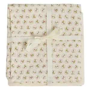 Delicately wrapped in a cream ribbon bow, the Doudou Swaddle Blanket by Bonpoint features folded cream-colored organic cotton adorned with petite pink and green florals. This charming bundle is the perfect baby gift—soft against delicate skin and bringing a hint of vintage elegance to every nursery.