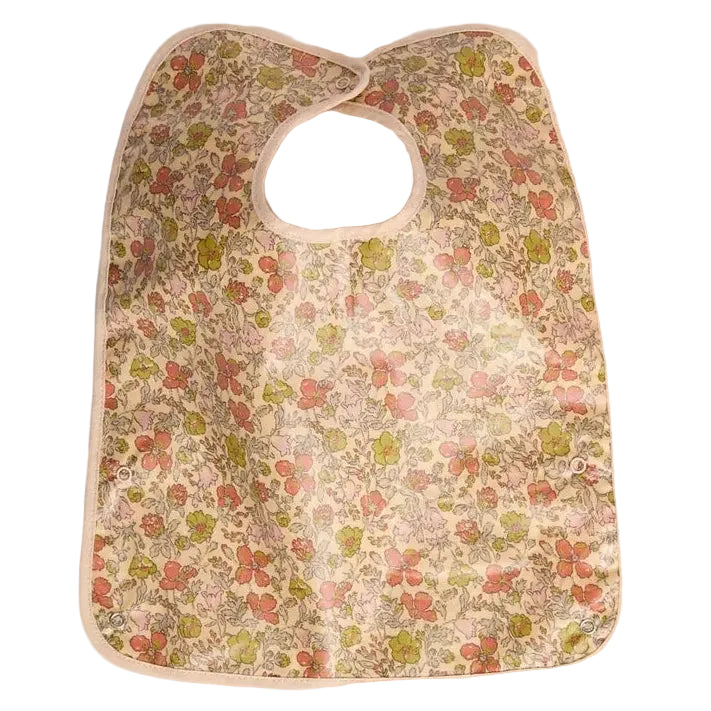 A clip-on bib by Bonpoint in yellow Liberty fabric, featuring a charming floral pattern and a practical plastic-coated finish.