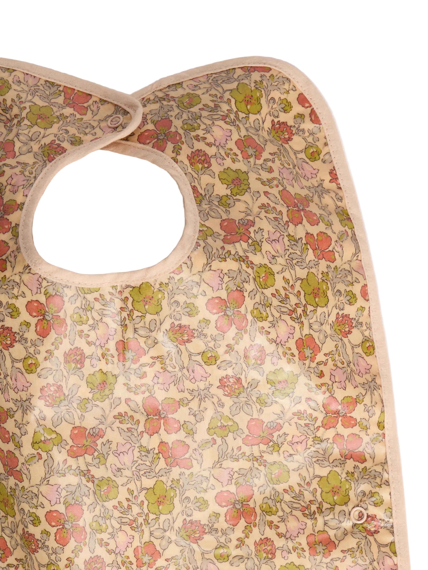 A close-up of the Bonpoint Clip-on Bib in Yellow Liberty Fabric, showcasing a charming floral pattern in shades of pink, red, and green on soft Liberty fabric with a convenient neck opening.