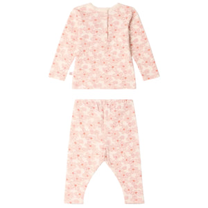 The Baby Girls’ and Girls’ Genna Set by Bonpoint features a pink long-sleeve top and matching pants with an all-over light pink and peach abstract dot pattern, crafted from soft organic cotton, displayed front and back on a white background.