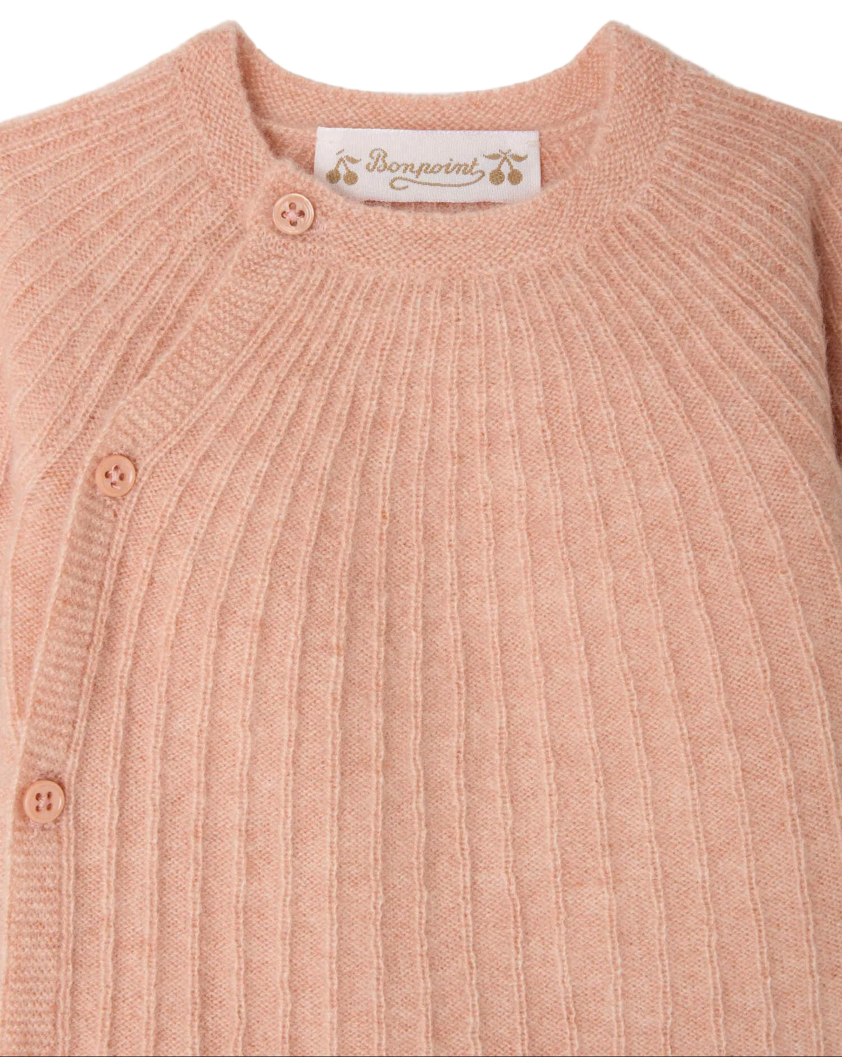 Close-up of the Baby Girls’ Ging Fancy-Stitch Set in Cashmere, a pink ribbed knit sweater with decorative stitch details and three buttons on the shoulder, featuring a Bonpoint label sewn inside the neckline.