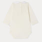 The Bonpoint Baby Cygne Bodysuit is a long-sleeve cream onesie made from soft organic cotton, featuring a white collar and button closure at the back, shown laid flat against a white background.