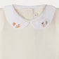 Close-up of the Bonpoint Baby Cygne LS Bodysuit in white, featuring a Peter Pan collar delicately hand-embroidered with small flowers and leaves on each tip. Crafted from soft organic cotton, this charming bodysuit is gentle on your baby’s skin.