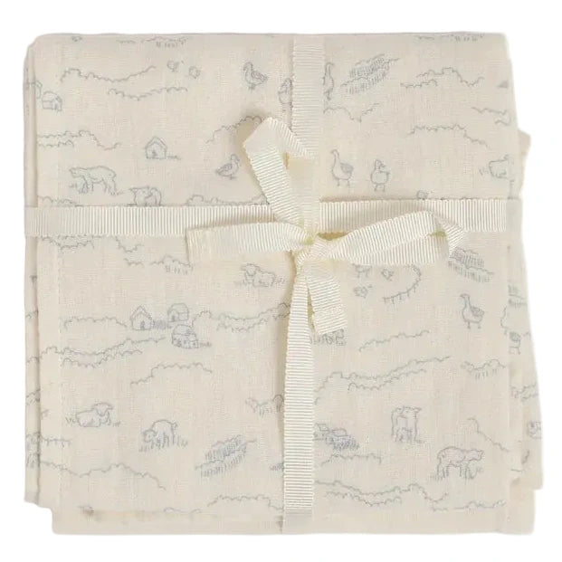 The Bonpoint Doudou Swaddle Blanket is a cream-colored muslin swaddle, crafted from organic cotton and adorned with a subtle animal and farm print. Elegantly folded and tied with a cream ribbon in a bow, it makes an ideal, thoughtful baby gift.