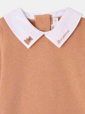 Close-up of Bonpoint’s Baby Boys’ Septembre Bodysuit in tan organic cotton, featuring a crisp white collar delicately hand-embroidered with “Bonjour” and a small gold teddy bear, capturing the timeless charm of the brand.