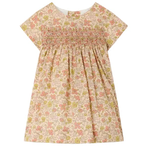 Bonpoint’s Baby Girls’ and Girls’ Maruska Dress features short sleeves, smocked and hand-embroidered detailing across the chest, a floral Liberty Tana Lawn fabric, and an A-line silhouette, shown against a plain background.