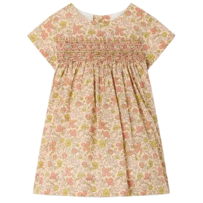 Bonpoint’s Baby Girls’ and Girls’ Maruska Dress features short sleeves, smocked and hand-embroidered detailing across the chest, a floral Liberty Tana Lawn fabric, and an A-line silhouette, shown against a plain background.