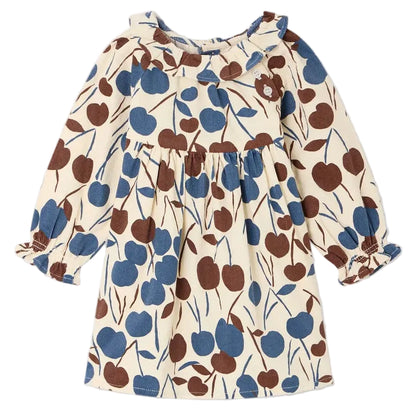 The Baby Girls’ Melyssa Dress with Cherry Print by Bonpoint is a cream-colored, long-sleeve dress crafted from organic cotton corduroy, featuring a blue and brown cherry pattern, a ruffled collar, and elastic cuffs.