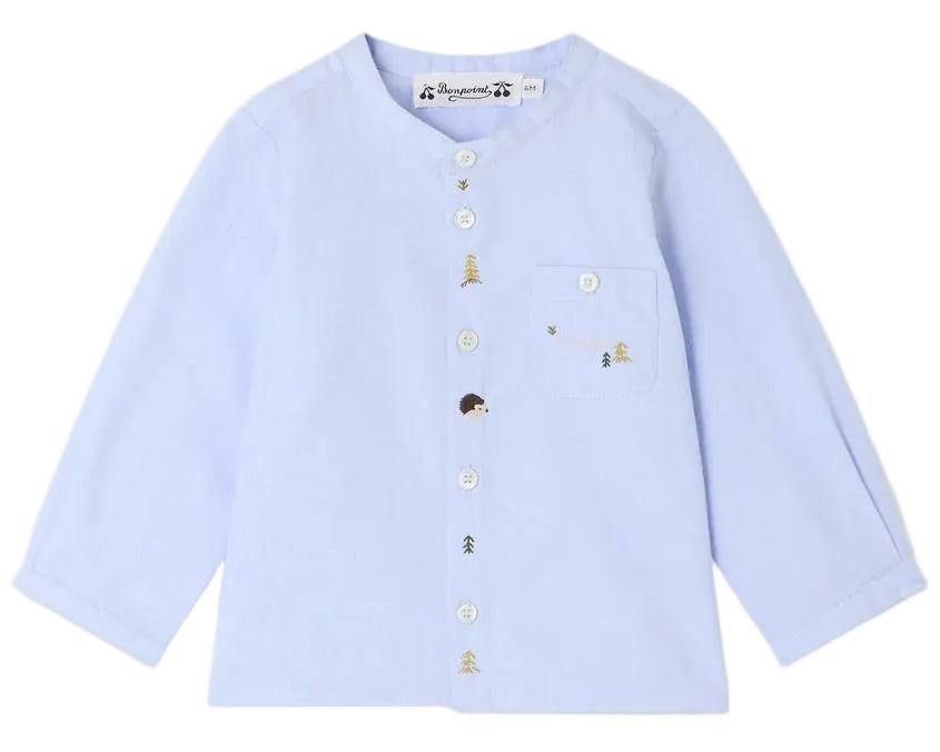 The Bonpoint Baby Boys’ and Boys’ Matis Shirt features a light blue, long-sleeve design with white buttons and a left chest pocket, adorned with charming hand-embroidered fir trees, hedgehogs, and bees.