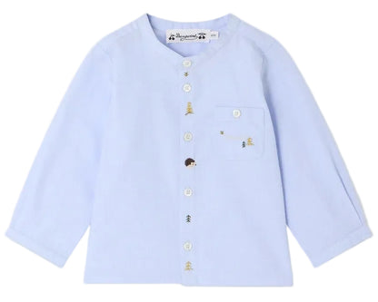 The Bonpoint Baby Boys’ and Boys’ Matis Shirt features a light blue, long-sleeve design with white buttons and a left chest pocket, adorned with charming hand-embroidered fir trees, hedgehogs, and bees.