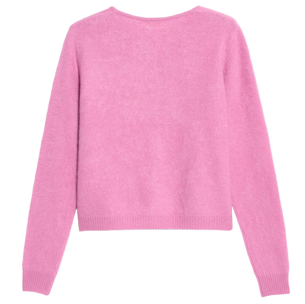 The Grizzly Cashmere Cardigan by Guest in Residence, a light pink women's knitwear sweater with long sleeves and a subtle brushed finish, is displayed flat with the back side facing up.