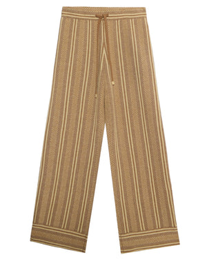 The Stripe Lounge Pant by Guest in Residence features brown and beige vertical stripes, a drawstring waist, and decorative hem stripes—offering stylish comfort as women’s loungewear.