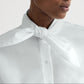 A person wearing the TWP Tie One On Shirt, styled with a white scarf knotted at the neck.