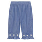The Louise Misha Baby Girls’ Mikani Set features blue chambray pants with ruffled hems and delicate white floral embroidery near the bottom of each leg, evoking the charm of an embroidered baby outfit. Shown against a white background, this set is perfect for creating a stylish look when paired with your favorite blouse.