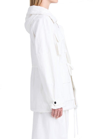 Person wearing the Proenza Schouler Nina Coat made from solid crinkle cotton, featuring a white hooded jacket with front pockets and an adjustable waist, shown in side profile against a plain white background.