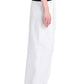 Dressed in a black top and oversized white Proenza Schouler Helena Pant, paired with black sandals, an individual poses in profile against a white background, highlighting the relaxed silhouette.