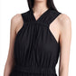 A woman models a sleeveless black Proenza Schouler Libby Dress, focusing on the ruched bodice and criss-cross neckline detail. Only her torso and face are visible against a light background.