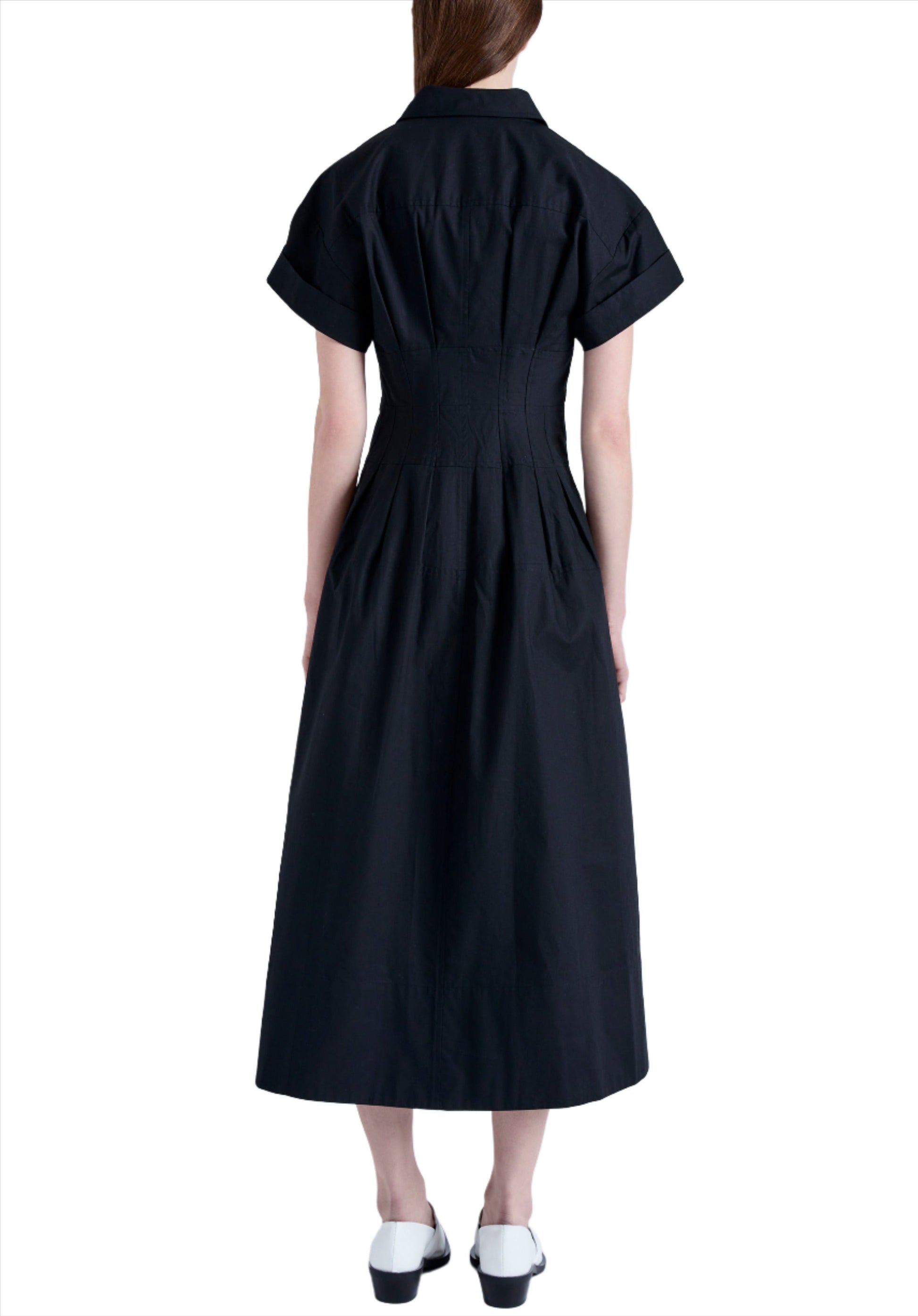 Person wearing a black, short-sleeve, collared, button-down Proenza Schouler Balston Dress, photographed from the back. They are also wearing white shoes with black soles.