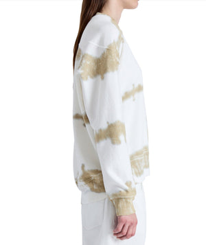 A person is seen in profile, wearing a Proenza Schouler Blake Tie Dye Sweatshirt by Proenza Schouler White Label, featuring a relaxed silhouette in calming white and beige tones, set against a simple backdrop.