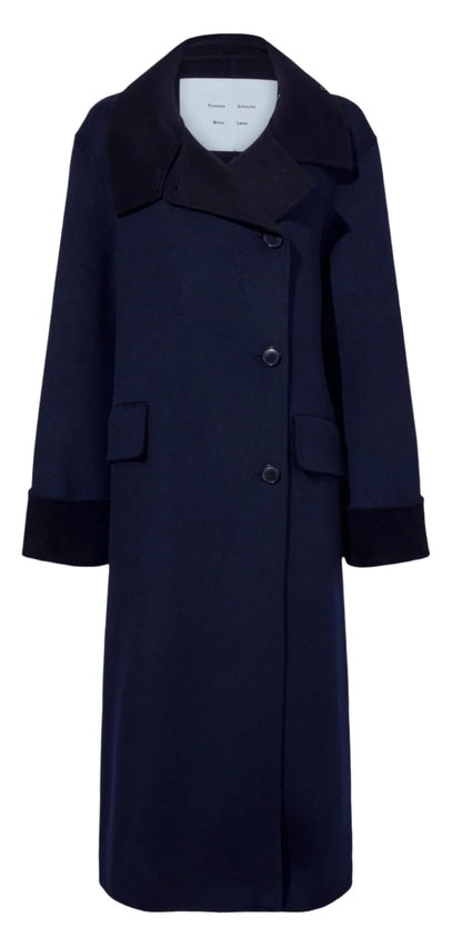 The Constance Pinstripe Melton Coat by Proenza Schouler White Label is a long navy coat with a contrasting black collar, double-breasted silhouette, button closure, cuffed sleeves, and two front pockets for added sophistication.