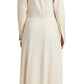 The scene features a person from behind in the Proenza Schouler White Label Lato Wrap Dress Linen Slub, a long-sleeved shirtdress in light beige, paired with black sandals.
