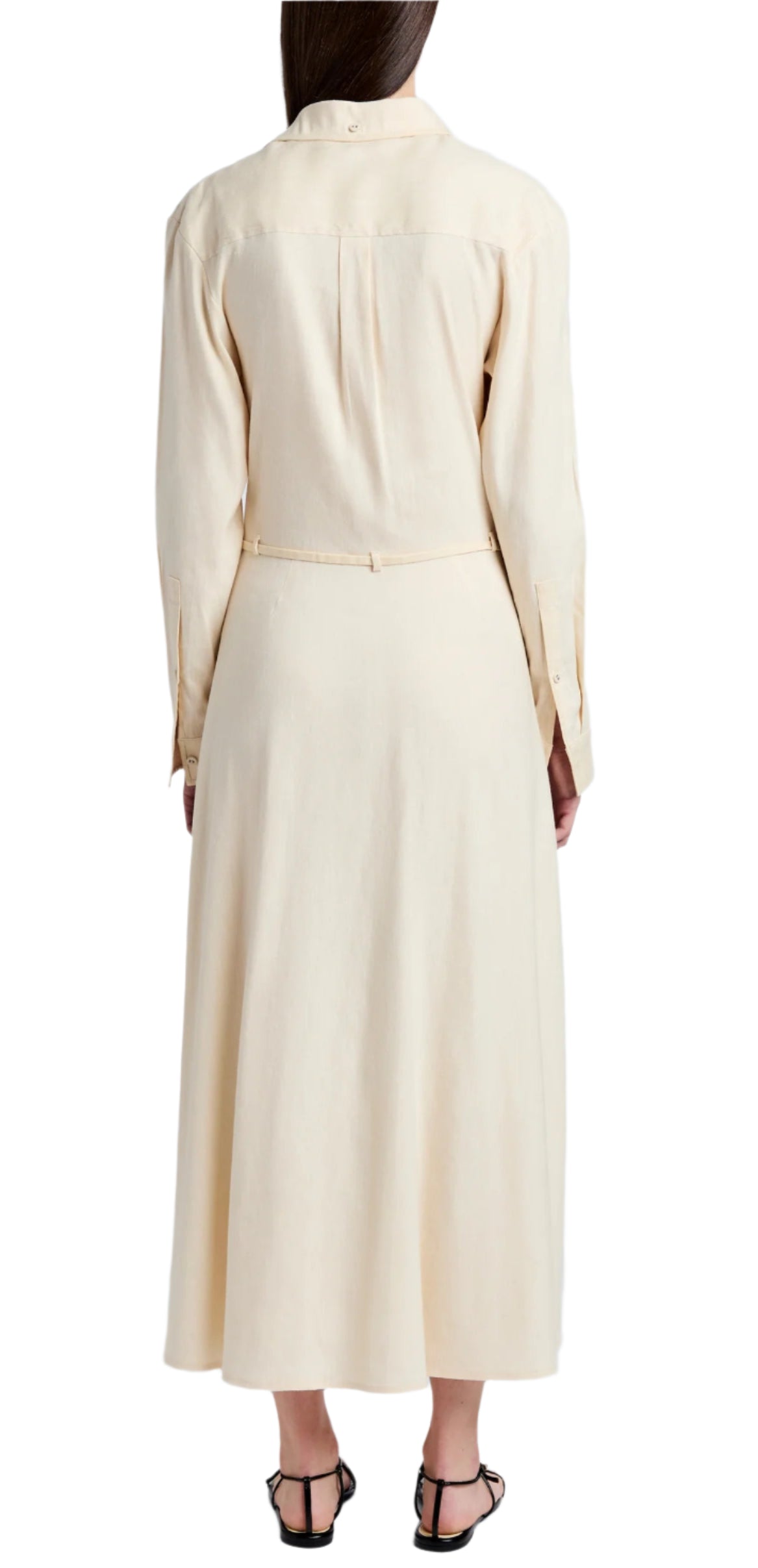 The scene features a person from behind in the Proenza Schouler White Label Lato Wrap Dress Linen Slub, a long-sleeved shirtdress in light beige, paired with black sandals.
