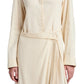 A person stands against a white background, wearing the Lato Wrap Dress Linen Slub by Proenza Schouler White Label, featuring a beige long-sleeve wrap design with a shirtdress silhouette and collared neckline.