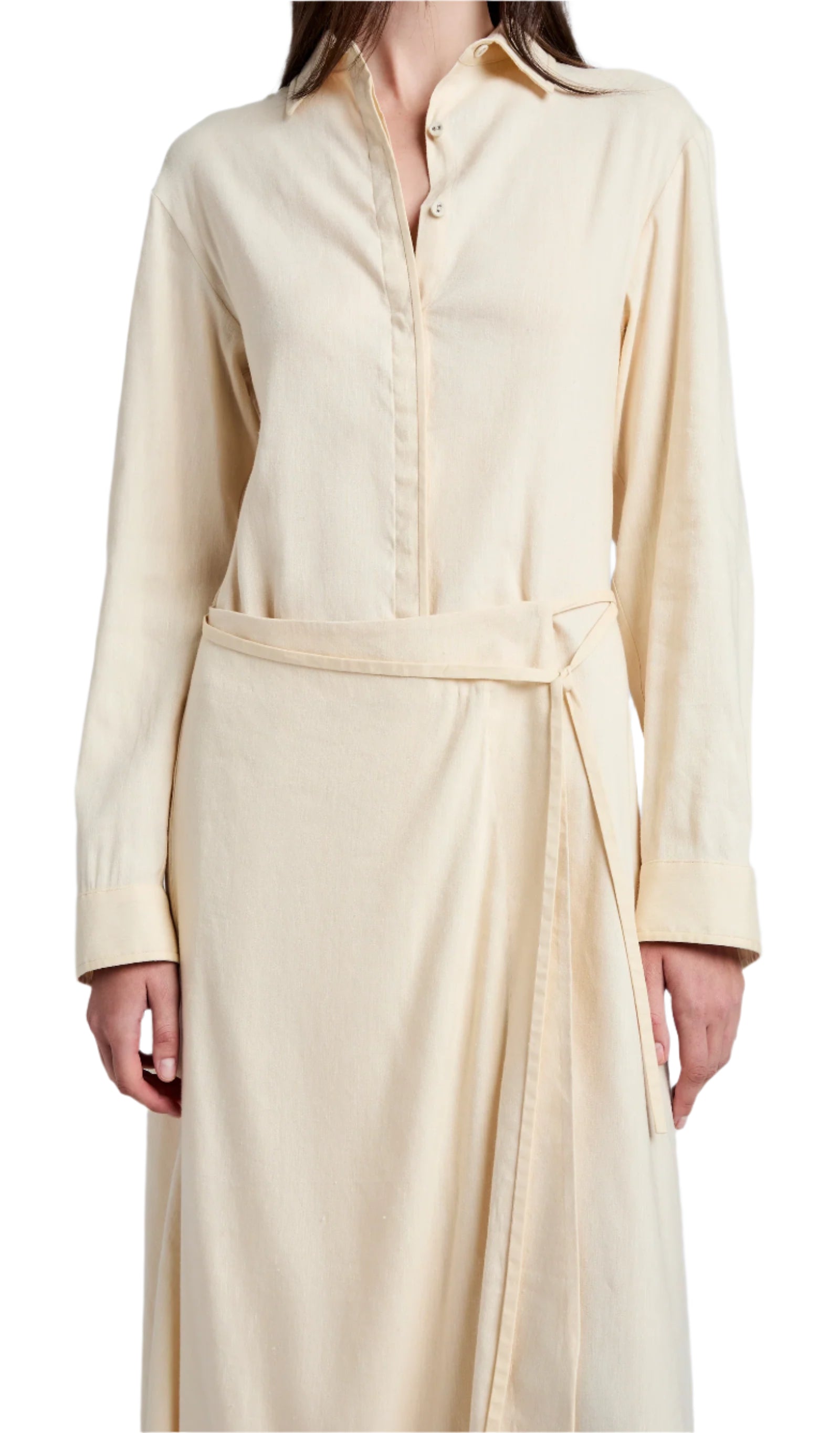 A person stands against a white background, wearing the Lato Wrap Dress Linen Slub by Proenza Schouler White Label, featuring a beige long-sleeve wrap design with a shirtdress silhouette and collared neckline.