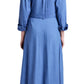 Someone is wearing the Lato Wrap Dress Linen Slub by Proenza Schouler White Label with black sandals, featuring a long-sleeve, button-up blue design and rolled cuffs for a classic shirtdress silhouette.
