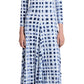 A person is wearing the Proenza Schouler White Label Jen Dress Printed Jersey with a blue and white patterned long-sleeve design, a touch of tie-dye, standing with arms at sides, paired with black sandals.