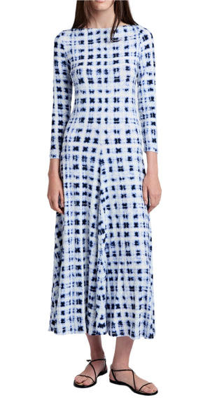 A person is wearing the Proenza Schouler White Label Jen Dress Printed Jersey with a blue and white patterned long-sleeve design, a touch of tie-dye, standing with arms at sides, paired with black sandals.