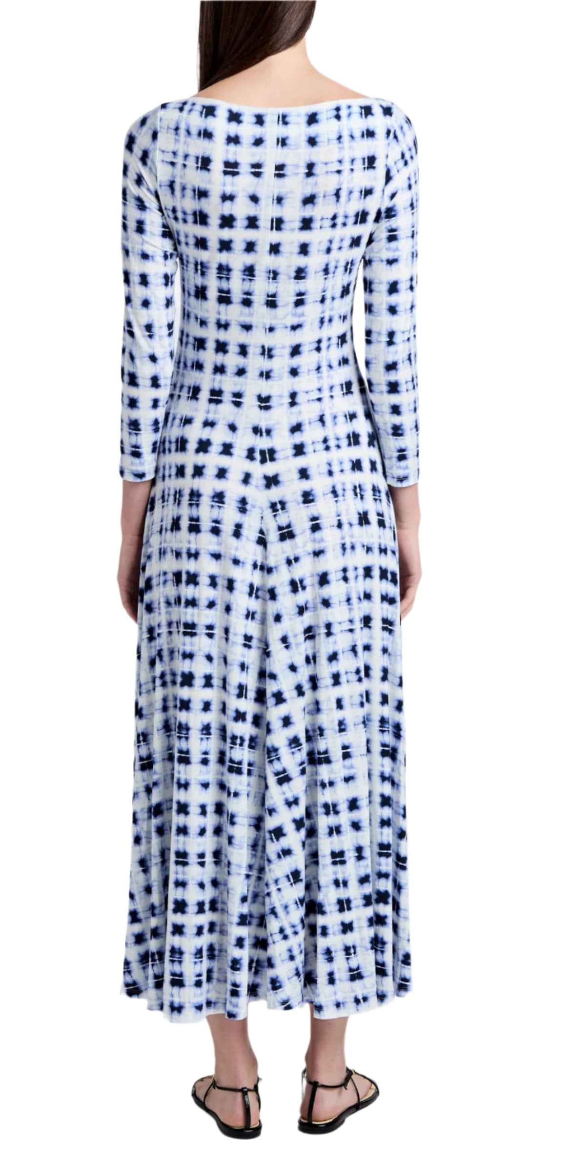 A person wearing a Proenza Schouler White Label Jen Dress Printed Jersey in blue and white tie-dye stands facing away, showcasing black sandals.