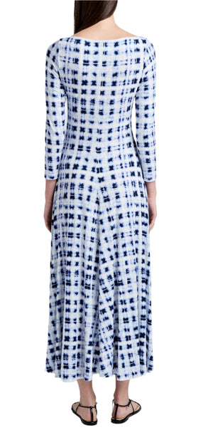 A person wearing a Proenza Schouler White Label Jen Dress Printed Jersey in blue and white tie-dye stands facing away, showcasing black sandals.