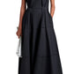 A woman wears the Proenza Schouler White Label Kailey Dress Stretch Poplin, a sleeveless, ankle-length pleated fit-and-flare style, paired with a white clutch and black sandals.