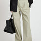 A person wears the Proenza Schouler White Label Romina Pant—relaxed fit, light beige, wide-leg—paired with a white top, black pinstripe shirt, black tote bag, and black sandals.