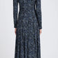 A person wears the Mabel Cheetah Jersey Dress by Proenza Schouler White Label, a long-sleeve, ankle-length dark blue dress with a white and light blue speckled pattern, shown from the back against a plain background.