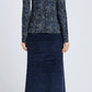 A person stands facing away in the Proenza Schouler White Label Audrey Cheetah Jersey Top, paired with a textured navy midi skirt and black boots against a plain light background.
