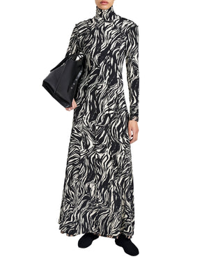 Wearing the Proenza Schouler White Label Mabel Marble Jersey Dress, this person pairs the black and white long-sleeve look with a black handbag and matching shoes.